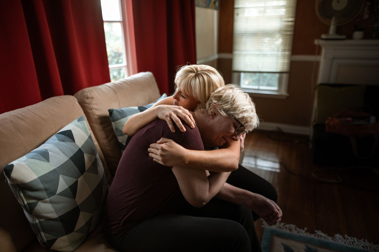 Two women embracing on a sofa